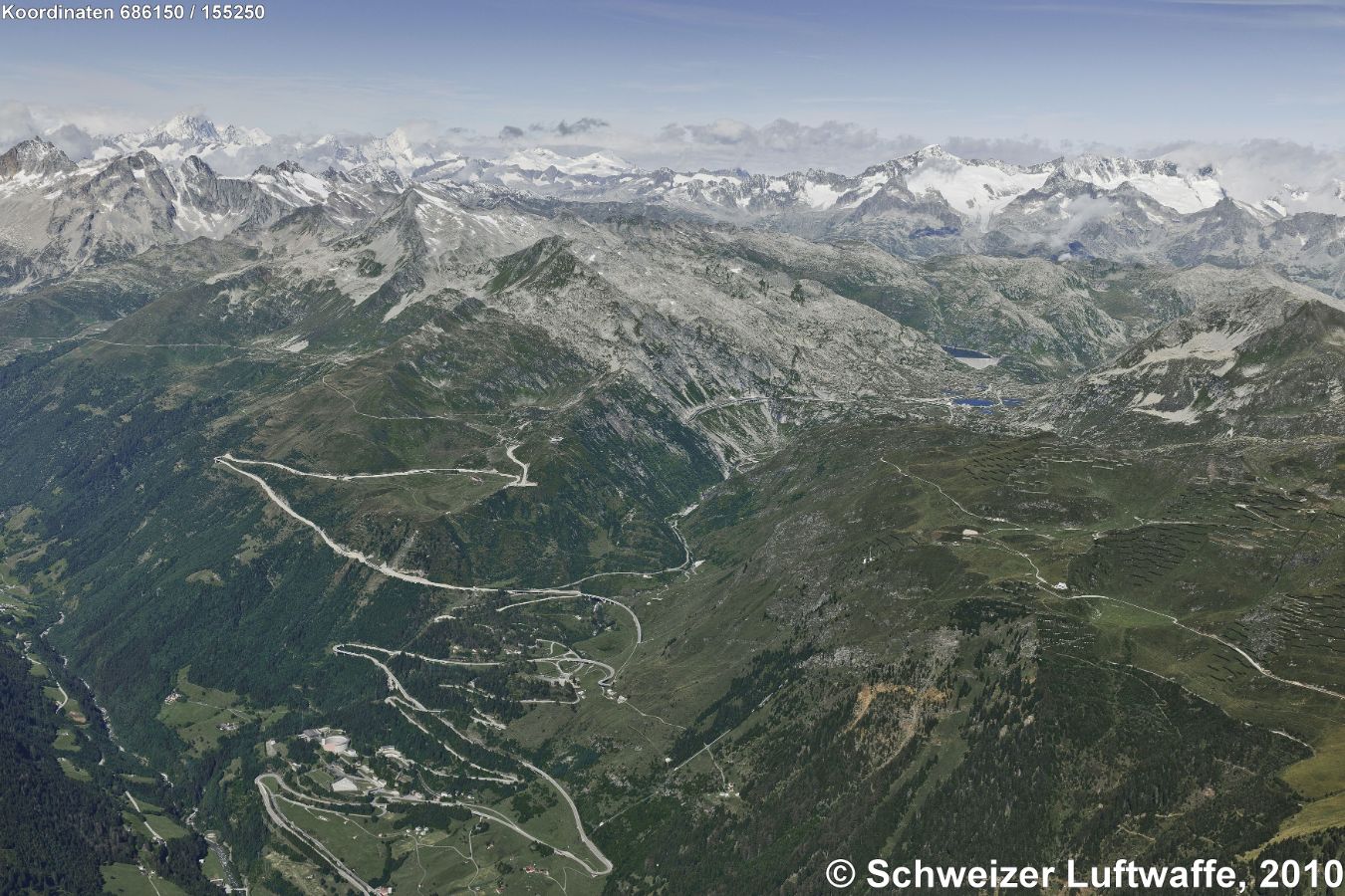 Gotthardpass Südseite: Bildrand ganz unten links Richtung Airolo, Bedrettozone; Passstrasse der Tremola; Bildmitte rechts: Hospiz; im Hintergrund: Stausee Lucendro